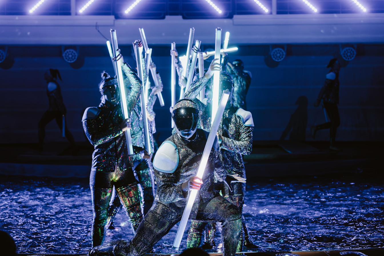 Cast performing with illuminated staffs