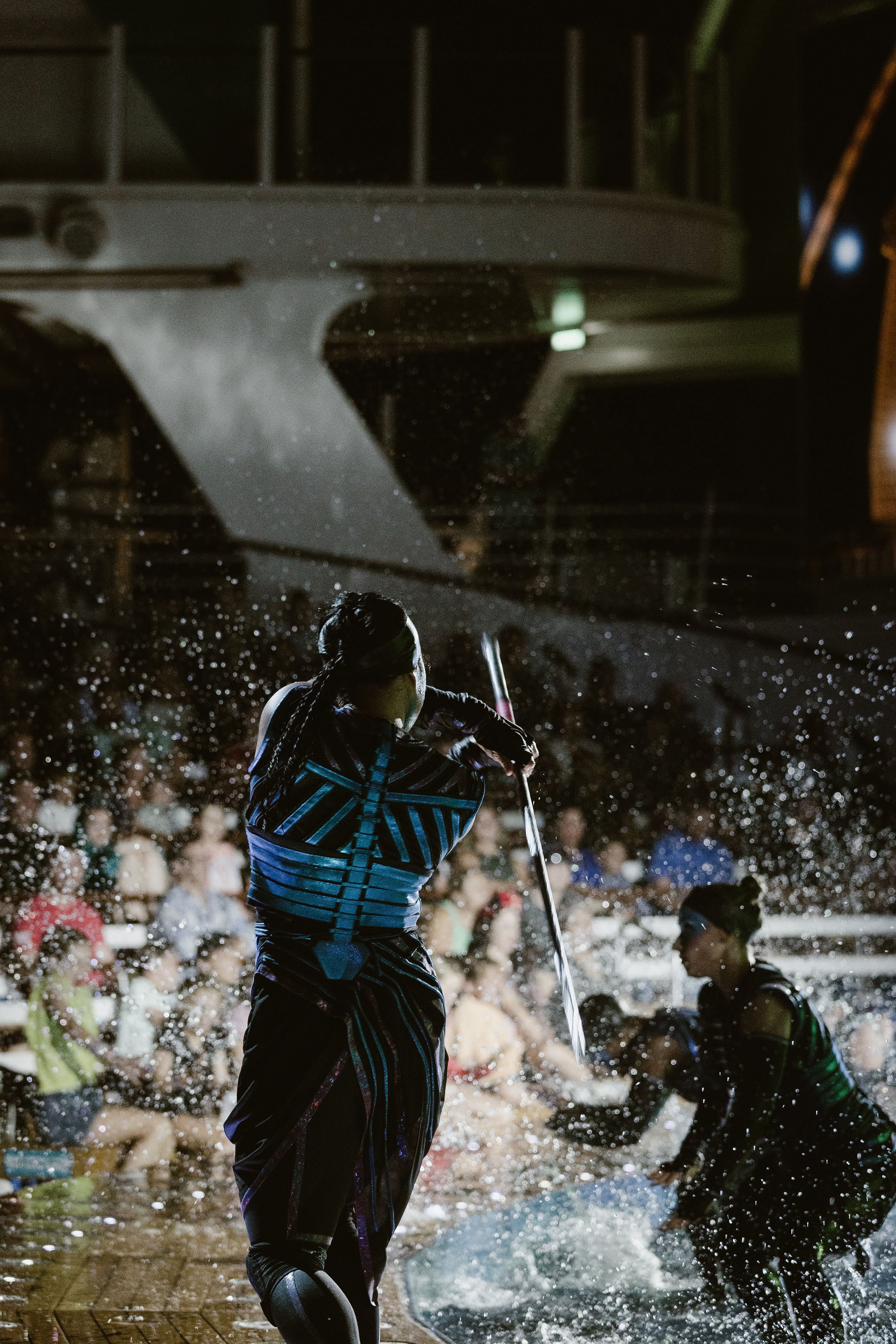 Rebecca mid-strike facing an audience through the spray