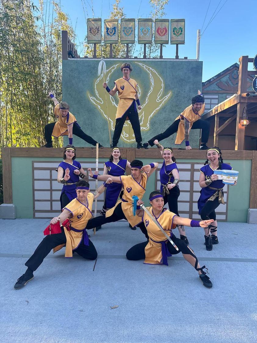 Wushu cast in Lego Ninjago-themed costumes performing on an outdoor stage
