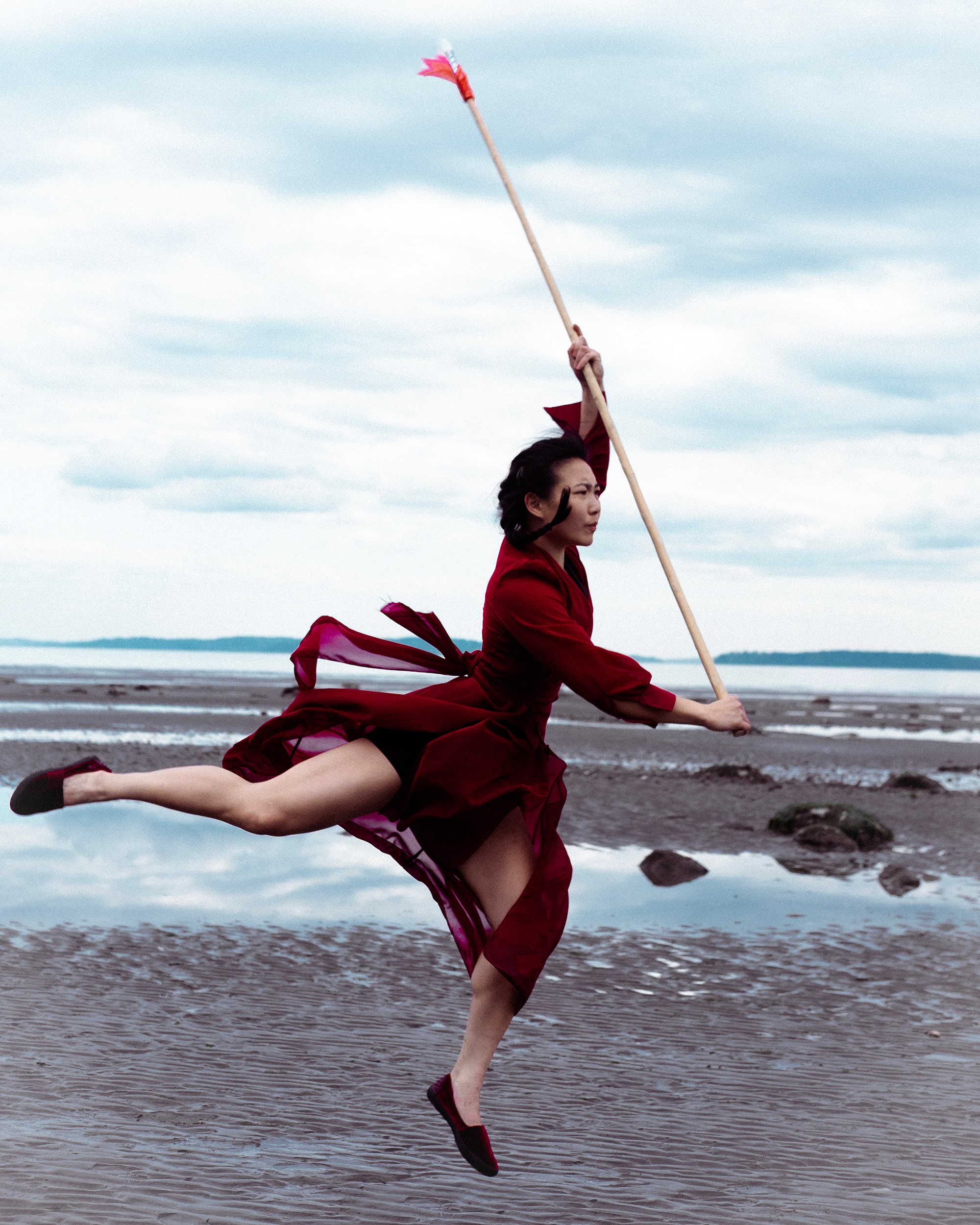 Flying spear pose on a beach at low tide